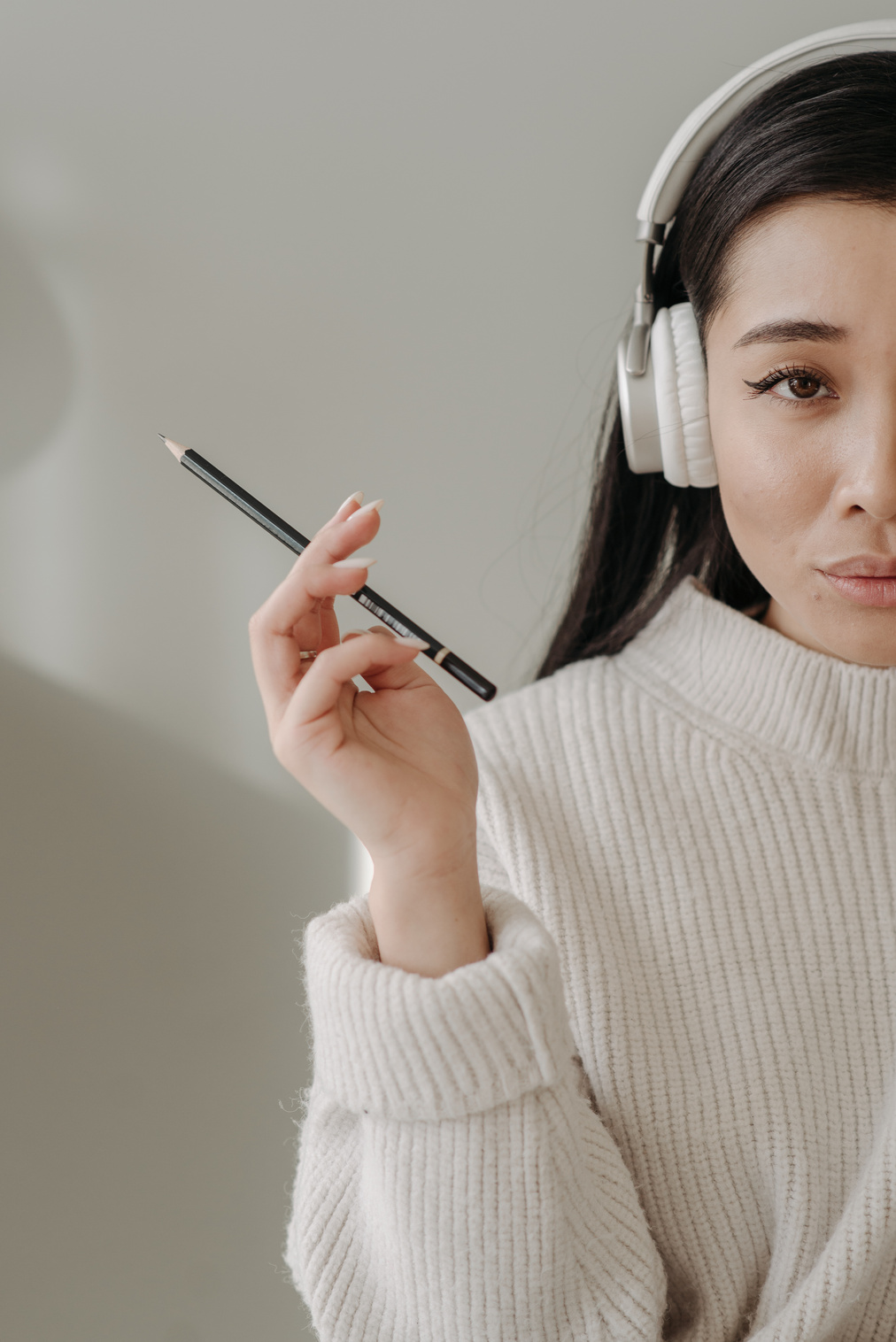 Woman in White Knit Sweater Holding Black Smartphone